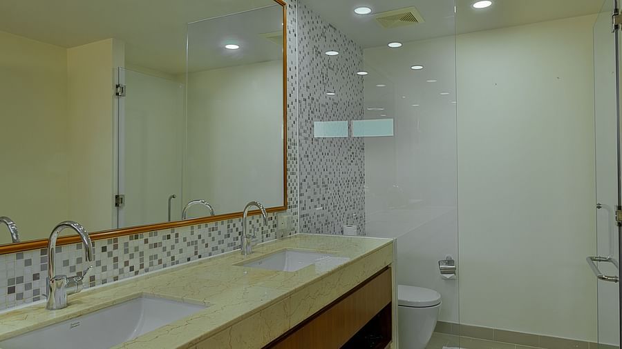 A spacious bathroom with a long vanity, double sinks, and a large mirror | Penthouse | Central Mansions, Phnom Penh