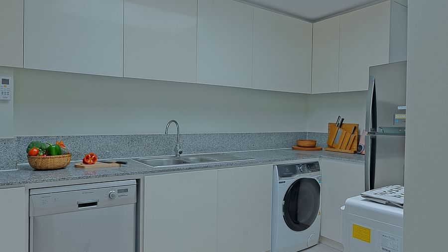 A kitchen with white cabinets, a sink, and a washing machine | Penthouse | Central Mansions, Phnom Penh