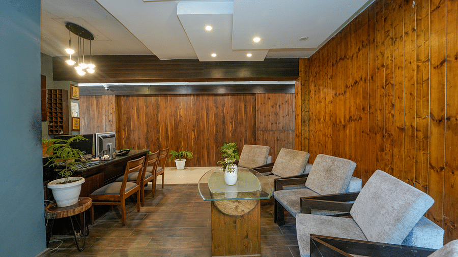 An image of the reception with a sofa set and a table - DLS Whispering Winds
