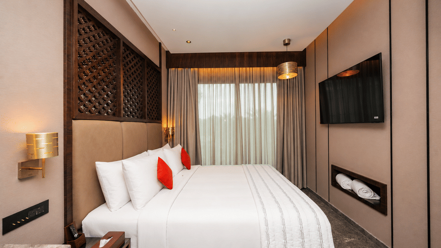 Loom Crafted Smart Room with king bed wall mounted television and Mysuru cultural design accents.