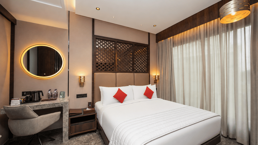 Smart room interior with vanity desk circular LED mirror and king bed at Ni Central Park.