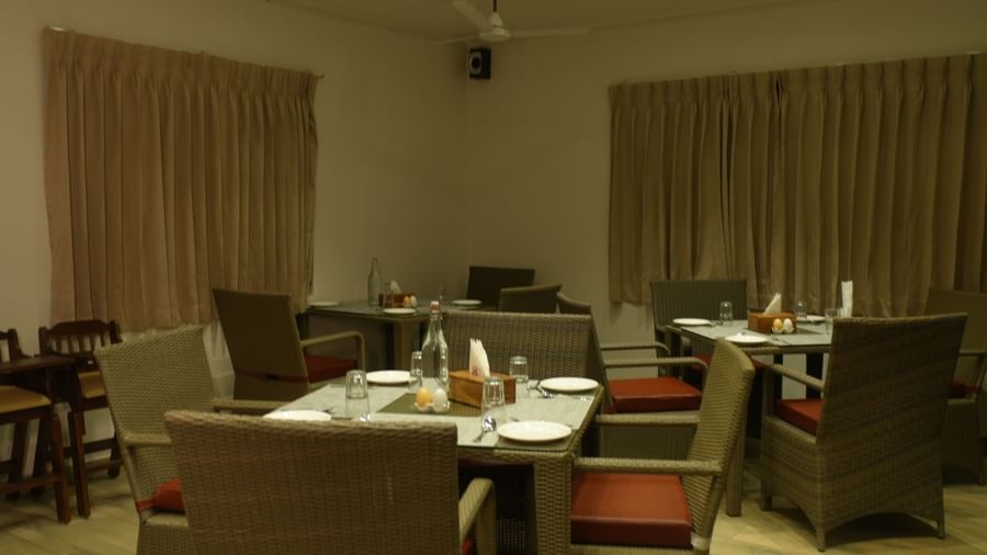 A dimly-lit dining area at the WOW Naturefull Resorts with closed curtains.