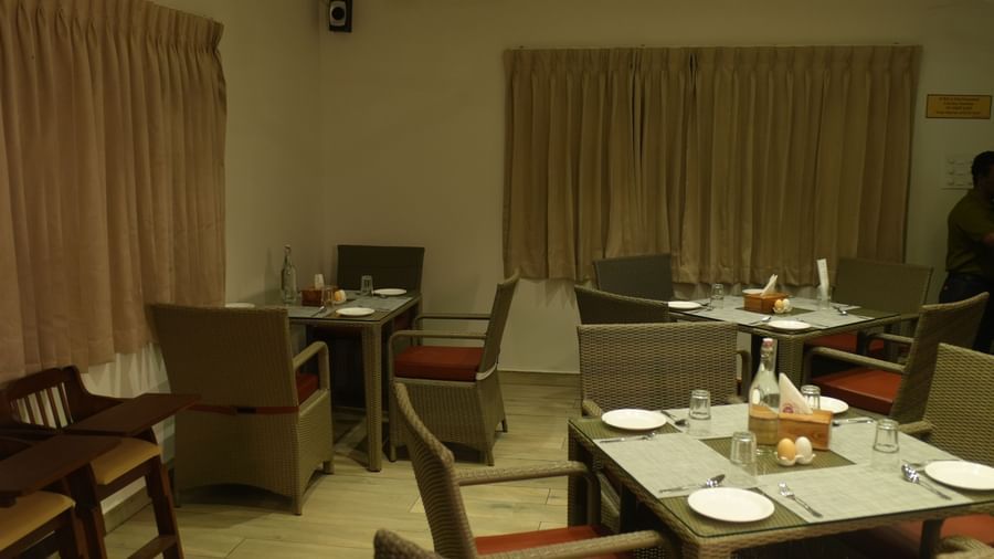 The dining area featuring well-arranged dining tables with plates and cutlery at WOW Naturefull Resorts.