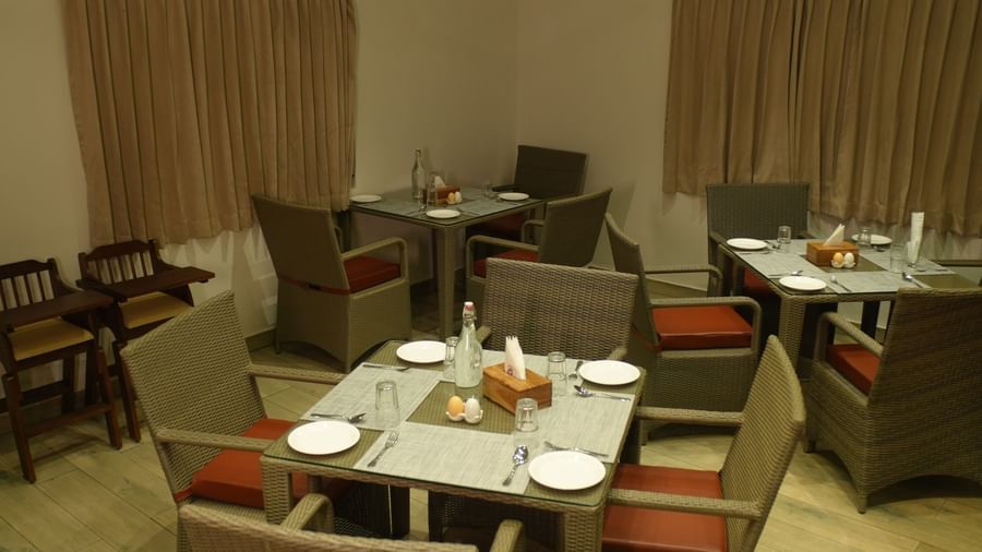 The restaurant of WOW Naturefull Resorts featuring a dining table with 4 chairs surrounding it.