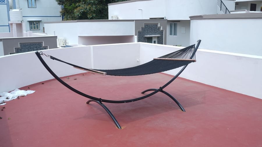 A hammock kept on the terrace area with red flooring at the Terrace Cottage at WOW Naturefull Resorts.