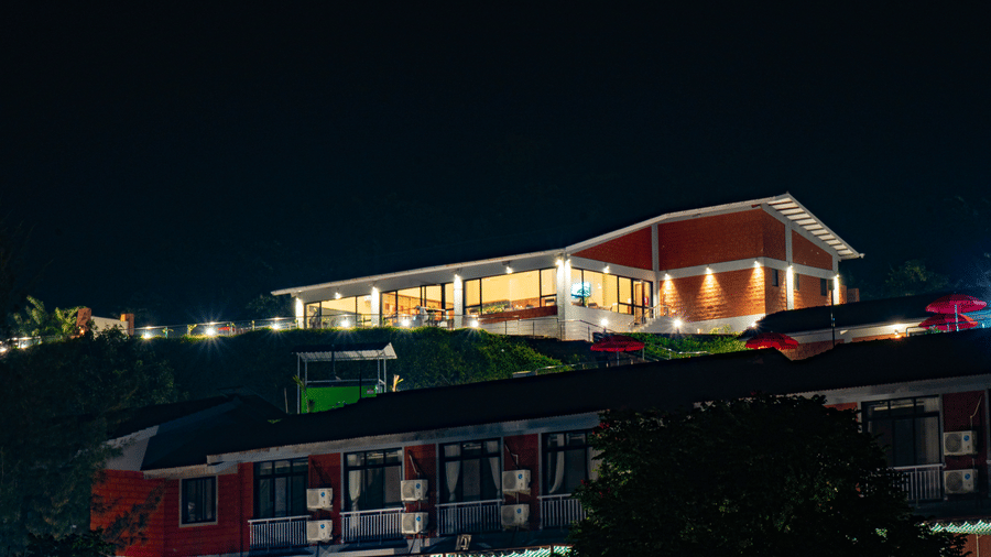 A building, lit at night and another building with no light