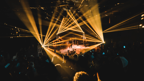 many people dancing and clubbing with laser lights shining everywhere