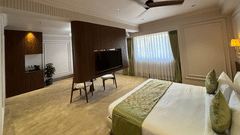 Spacious executive hotel suite at Biznotel by Pride Surat featuring a king bed, central TV partition, and modern furnishings.