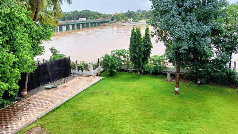 An overview of the Front Lawn area with trees surrounding the perimeter, overlooking the waterbody - VITS Kamats Resort, Silvassa