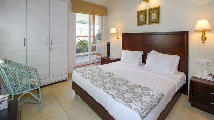 Closer view of deluxe room with tidy white linens and wardrobe on the side along with bedside lamps enhancing the beauty of the room - Lamrin Norwood Green, Palampur
