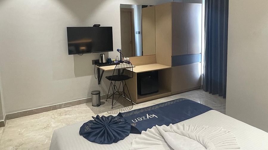 Contemporary suite with a wall-mounted TV, desk, and ample natural light at Hotel Kyzen HiTech City – Your Zenly Stay