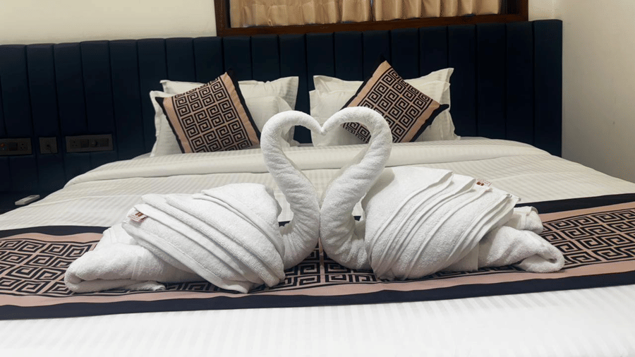 Decorative swan towel art on a prepared hotel bed - Lords Swastik Studio, Kodinar