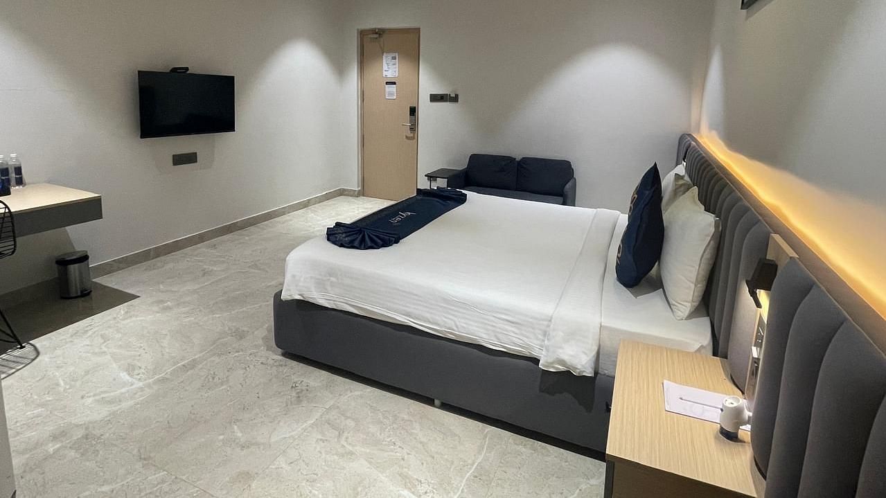 Suite with king size bed and soft lighting  on the headboard at Hotel Kyzen HiTech City – Your Zenly Stay