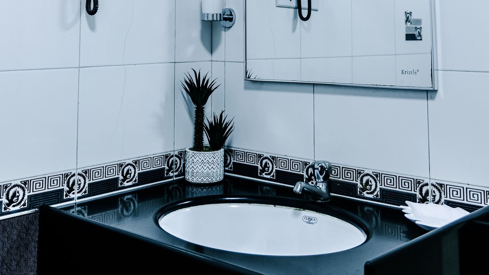image of a wash basin along with a half mirror in the grand suite bathroom - The Grand Krishna Rooms, Bengaluru