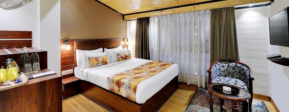 Image of a room with a bed, a seating area and a television at  Yashshree Mall Road, Darjeeling.