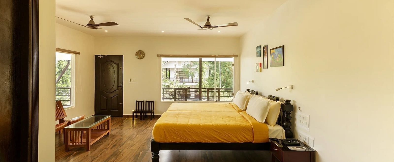 A bedroom with a bed, colorful rugs, and a view through a doorway.