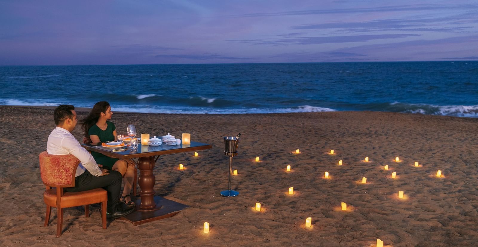 A romantic candlelight dinner setup on a pristine sandy beach – Kaldan Samudra Palace, one of the top 5 Star Restaurants in Mahabalipuram ECR, offering an unforgettable dining experience by the sea