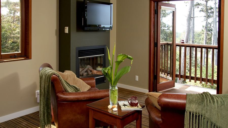 A corner in one of rooms featuring a fireplace, wooden accents, a teapoy, and couches - Brewery Gulch Inn & Spa