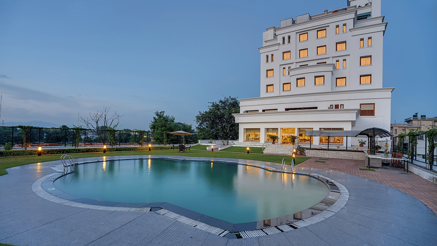 Swimming Pool at Hotel Royal Sarovar Portico Siliguri Hotels, with the facade and sky in the backdrop.