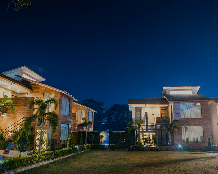 Night View of a Luxurious Resort with Illuminated Buildings and Lush Green Lawn
