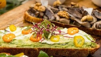 Toasted open sandwich with vegetables and mushrooms, served with condiments and a side of watermelon at Karma Chalets..