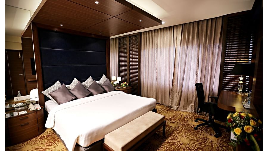 a plush king size bed with a stack of pillows on top of it at Executive Suites in Vizag