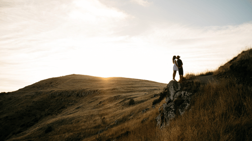 Couple on a green meadow of a mountain