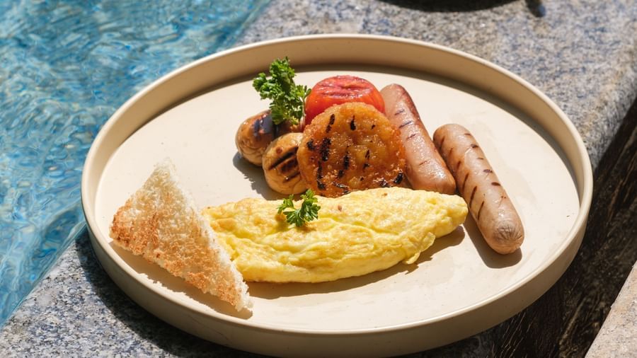 A palte of Masala Omlette with Sausages with a cup of coffee next to it | Mango Hill, Pondicherry