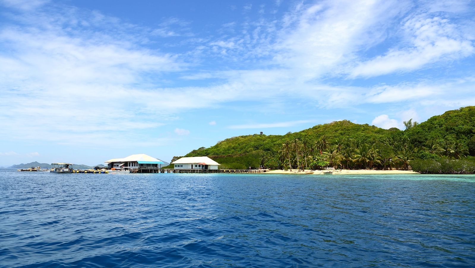 Ocean view with distant island and boats near Flower Island Resort.