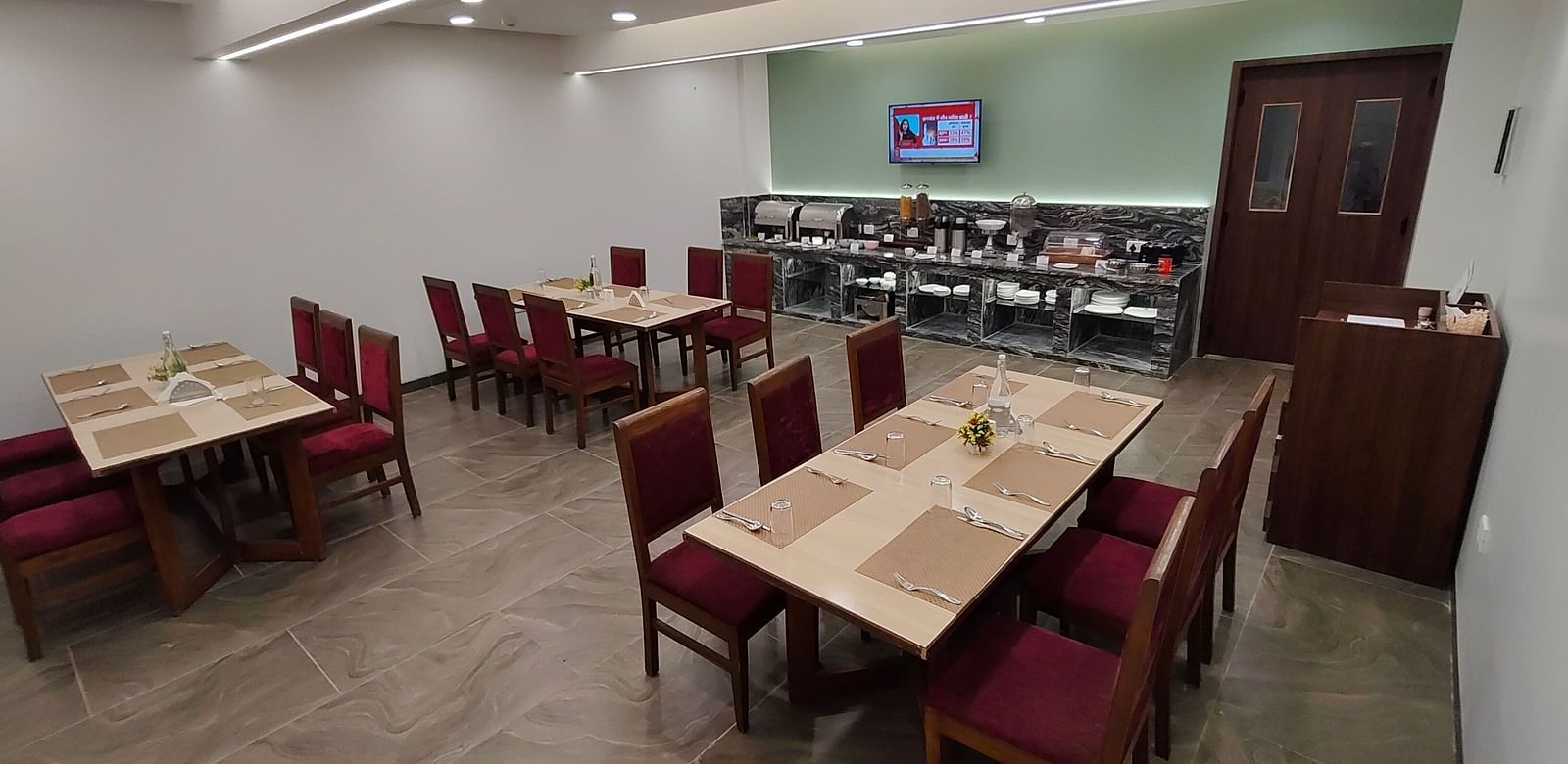 Restaurant-style dining area with red chairs and wooden tables
