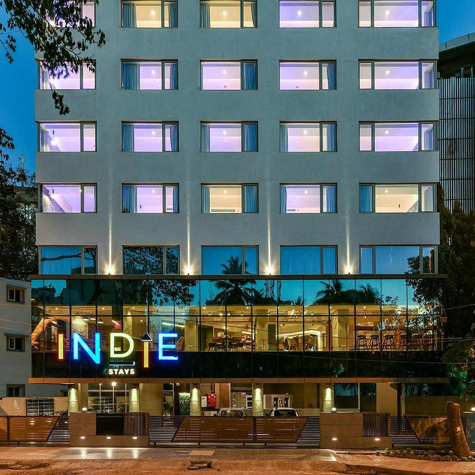 The facade of Indie Stays, BKC, shines against the night sky, with interior lights illuminating the building, creating a highlighted and inviting look