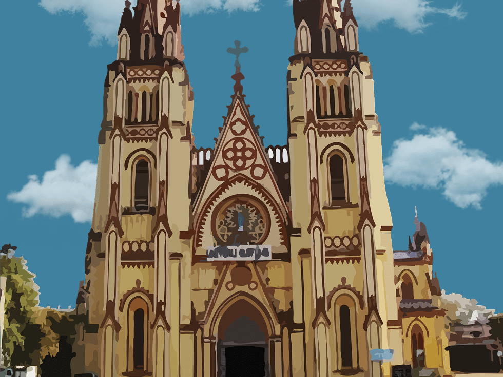 A grand Gothic-style church with twin spires under a bright blue sky, surrounded by greenery.