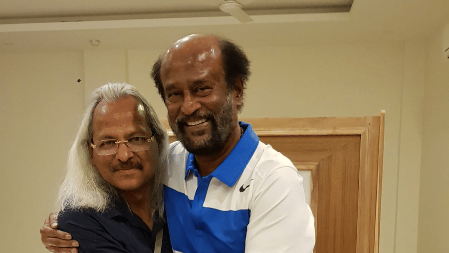 Rajnikanth, a tamil movie superstar, hugging the owner of Shaheen Bagh and posing for a picture inside a room.
