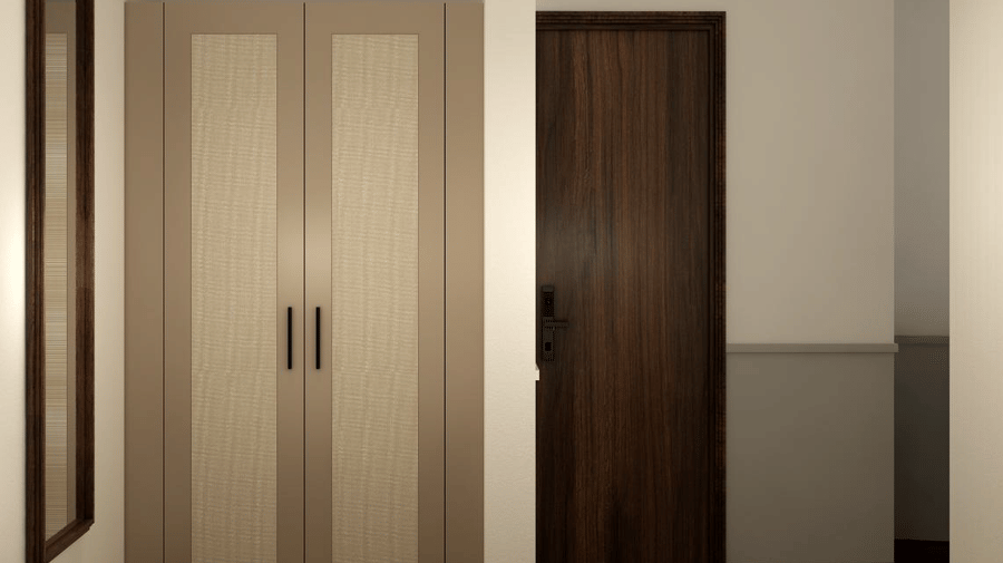 A 2-door wardrobe standing next to a dark wooden door in a room with white walls and a dark carpet at Shilton Suites, Bengaluru.