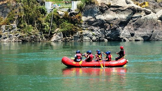 a group of people spotted in a rafting boat white river rafting in a river enclosed by mountain