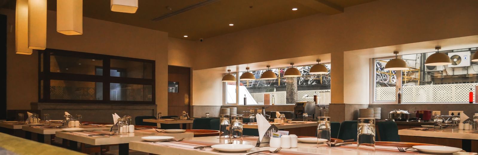 An inviting restaurant interior with neatly set tables and elegant lighting, ready for diners at Shilton Dee Cee.