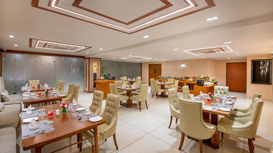 A hotel dining area with tables and chairs, prepared for breakfast or other meals - SK Lords Inn Ahmedabad