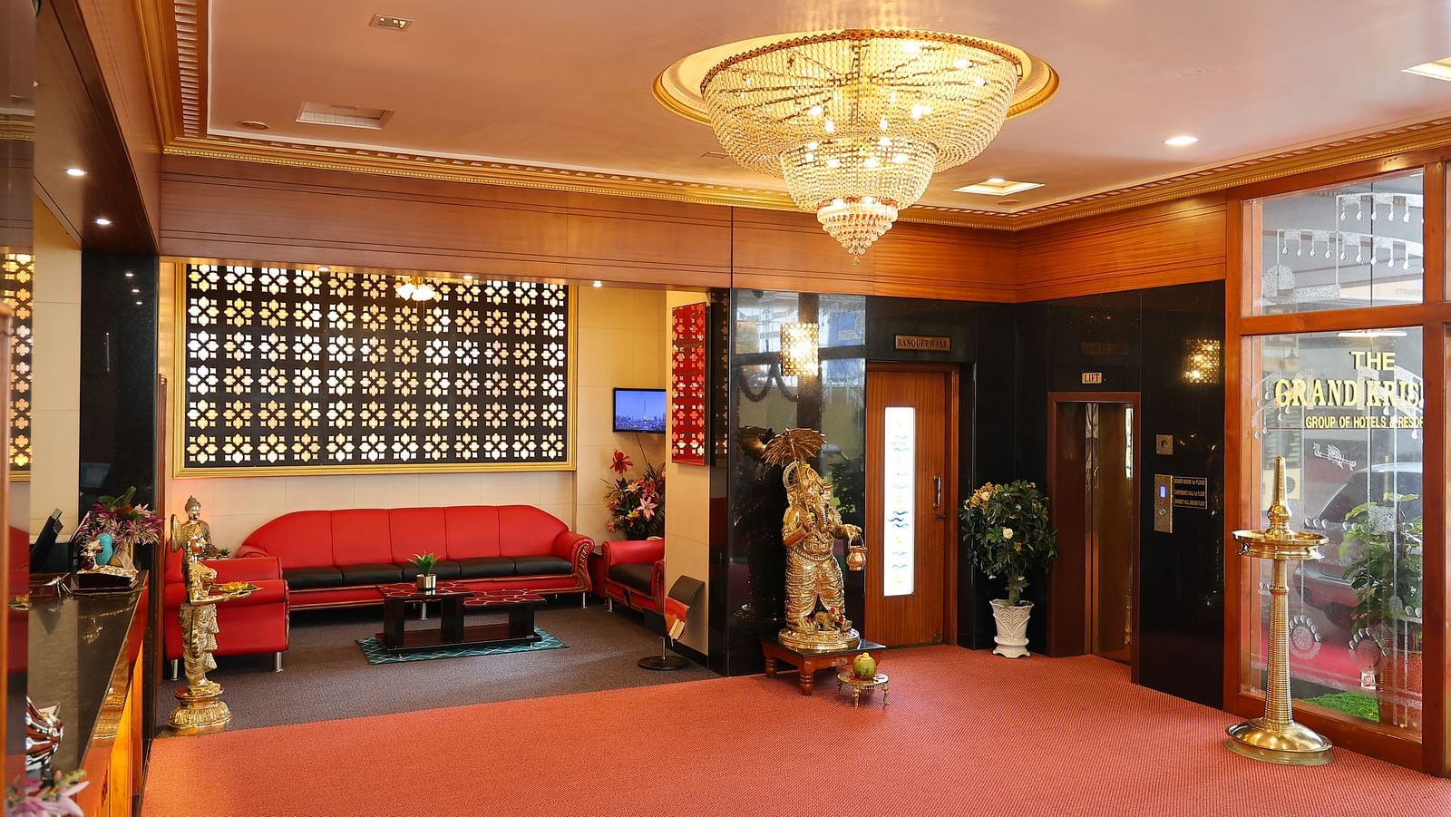 Image of the Lobby of The Grand Krishna Rooms, Bengaluru featuring a beautiful chandelier hanging from the ceiling