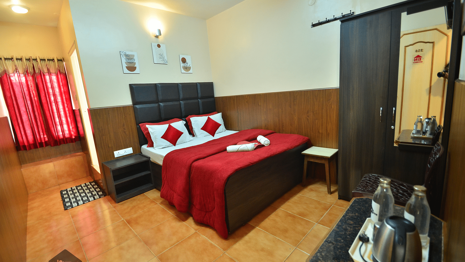 Image of a room with a bed, wardrobe, electric kettle and water bottle at BN Tourist Home, Ooty