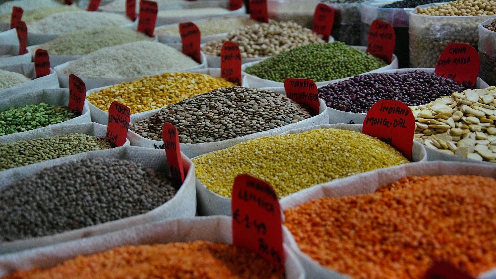 An image featuring a variety of Indian pulses stored in bags, neatly arranged in rows with name tags.