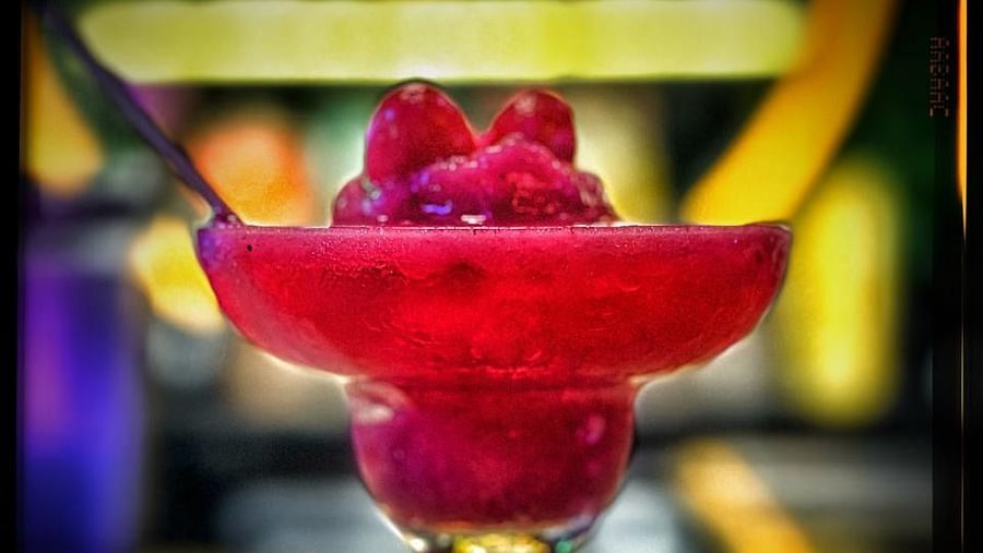 A vibrant drink in a stemmed glass, against a softly blurred background at Cenneys Gateway.