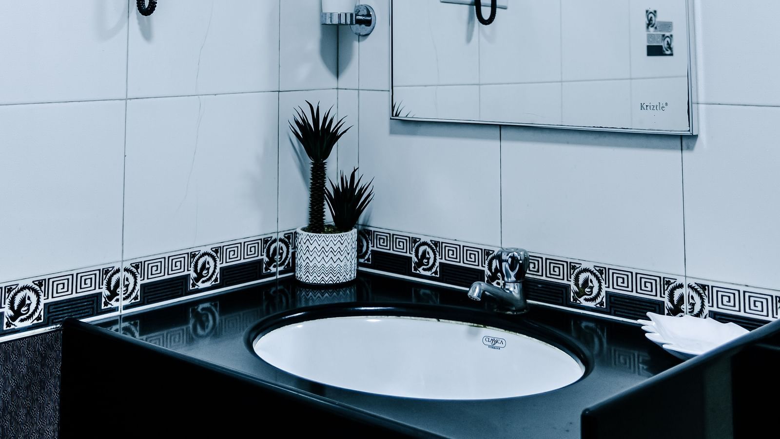 image of a wash basin along with a half mirror in the grand suite bathroom - The Grand Krishna Rooms, Bengaluru