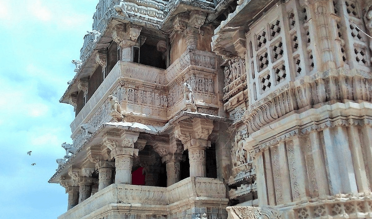 Intricately carved stone temple structure with columns and balconies.