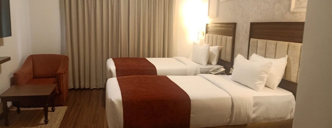 Luxury King Room with two beds, white linens, and a red runner at at Nalapad Hotel Bangalore International.