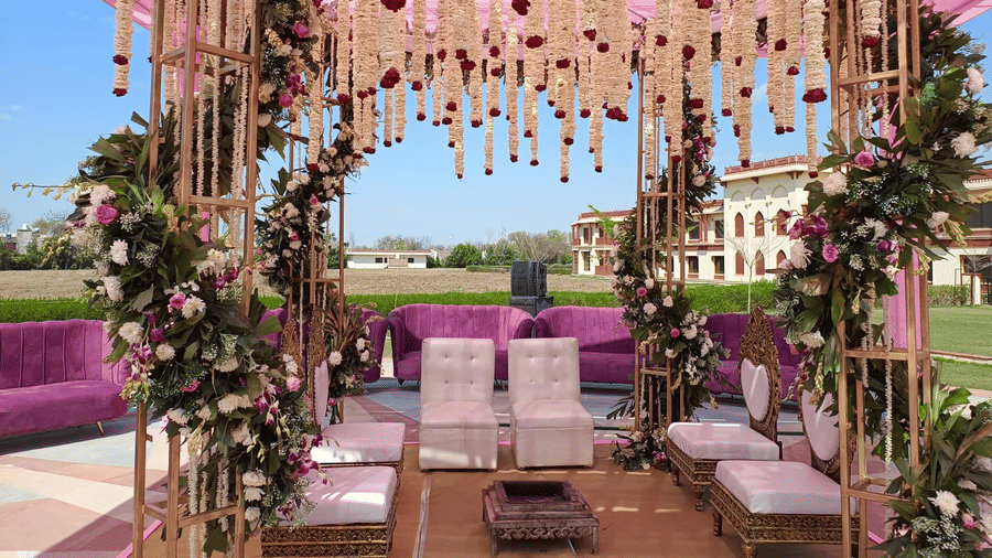 A beautifully decorated mandap at The Ummed Jodhpur, with floral arrangements, chairs, and a view of the surrounding landscape.