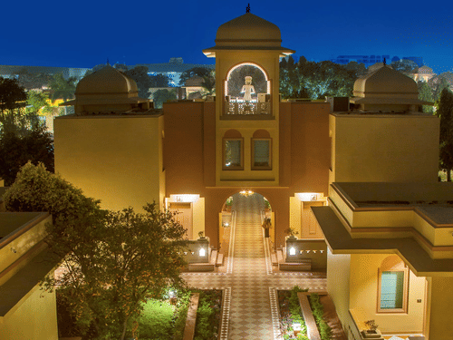 A beautifully illuminated courtyard of Heritage Village Resort & Spa, Manesar, one of the luxury resorts in Gurgaon, with elegant Rajasthani-inspired architecture and landscaped surroundings.