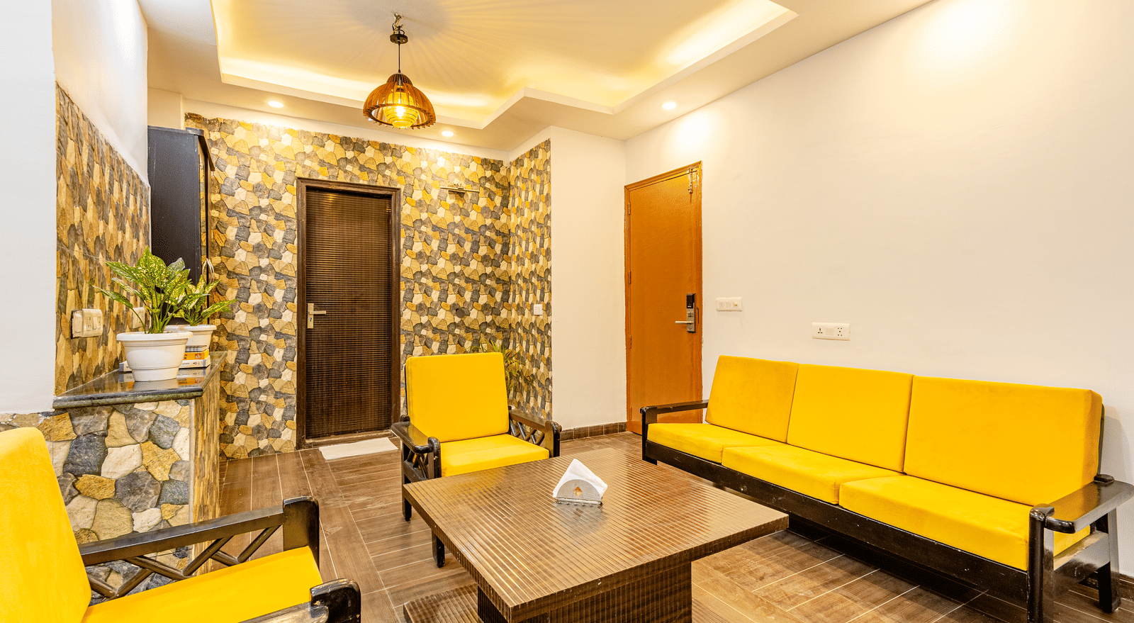 Another angle of the yellow sofas in the living room in the Suite at Lime Tree Hotels and Banquet Hall Near Huda Metro, Gurgaon
