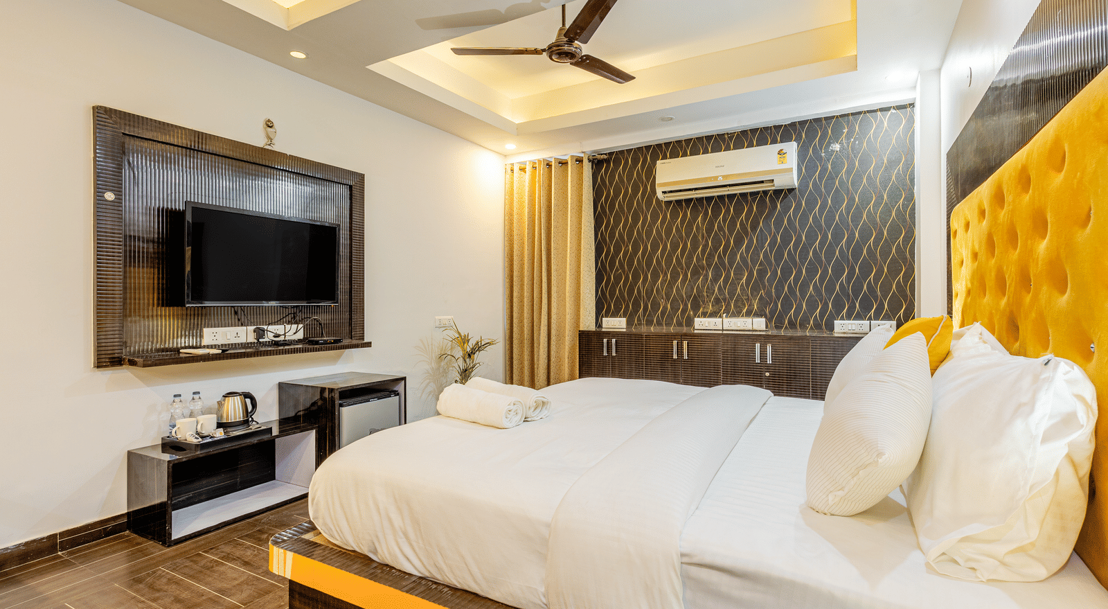 Side view of the king size bed with television in front of it in the superior King room at Lime Tree Hotels and Banquet Hall Near Huda Metro, Gurgaon