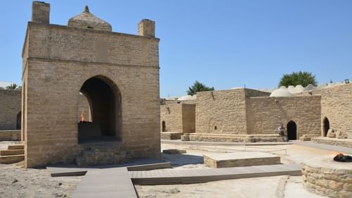 Exterior of a fort on a sunny day, featuring brick-built structures with pointed domes.