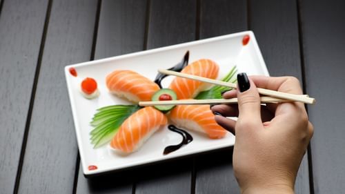 woman eating sushi with chopsticks